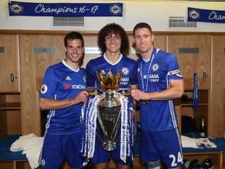 Cesar Azpilicueta of Chelsea, David Luiz of Chelsea and Gary Cahill of Chelsea pose with the Premier League Trophy in the changing room after the Premier League match between Chelsea and Sunderland at Stamford Bridge on May 21, 2017 in London, England.