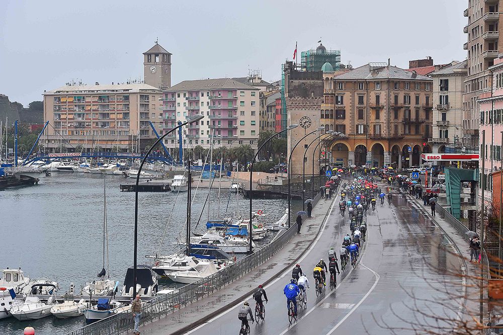 The peloton rides through the wet weather.