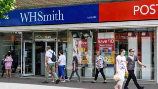 Couple walking past a WH Smith store in a high street