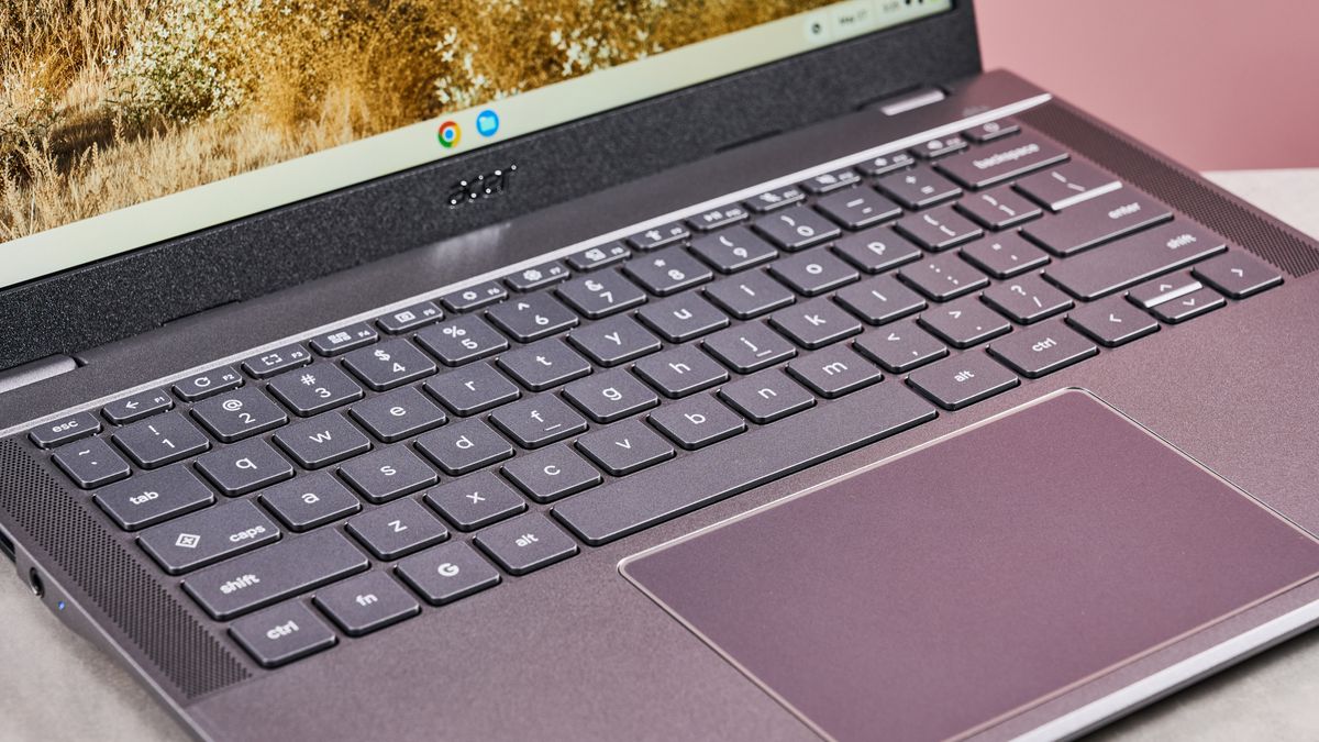 Close-up of keyboard and touchpad on Acer Chromebook Plus 516, open on desk with pink background