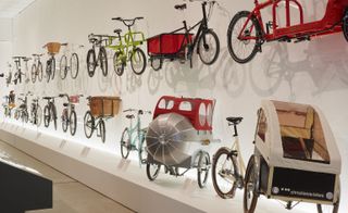 A selection of bikes from throughout the ages displayed on a white wall