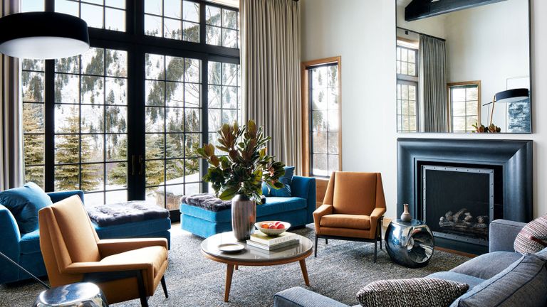living room with blue velvet chaises, grey sofa, tobacco hued armchairs and fireplace