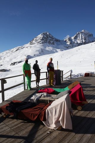 Terrace of restaurant looking out onto ski slopes with Extreme Cashmere mannequins in knitwear