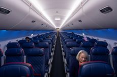 Passengers sitting in a mostly empty Delta airplane.