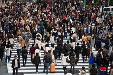 A crowd crosses a street