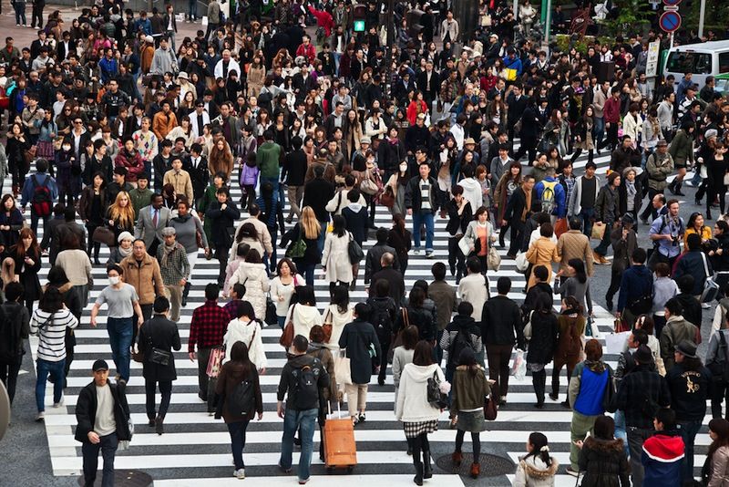 A crowd crosses a street