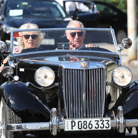 King Charles and Queen Camilla driving in a convertible