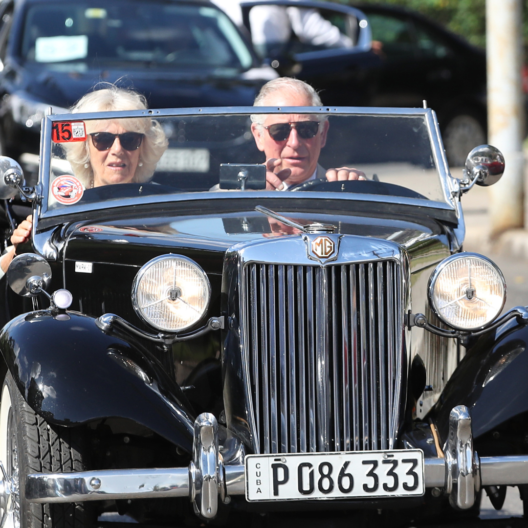 King Charles and Queen Camilla driving in a convertible