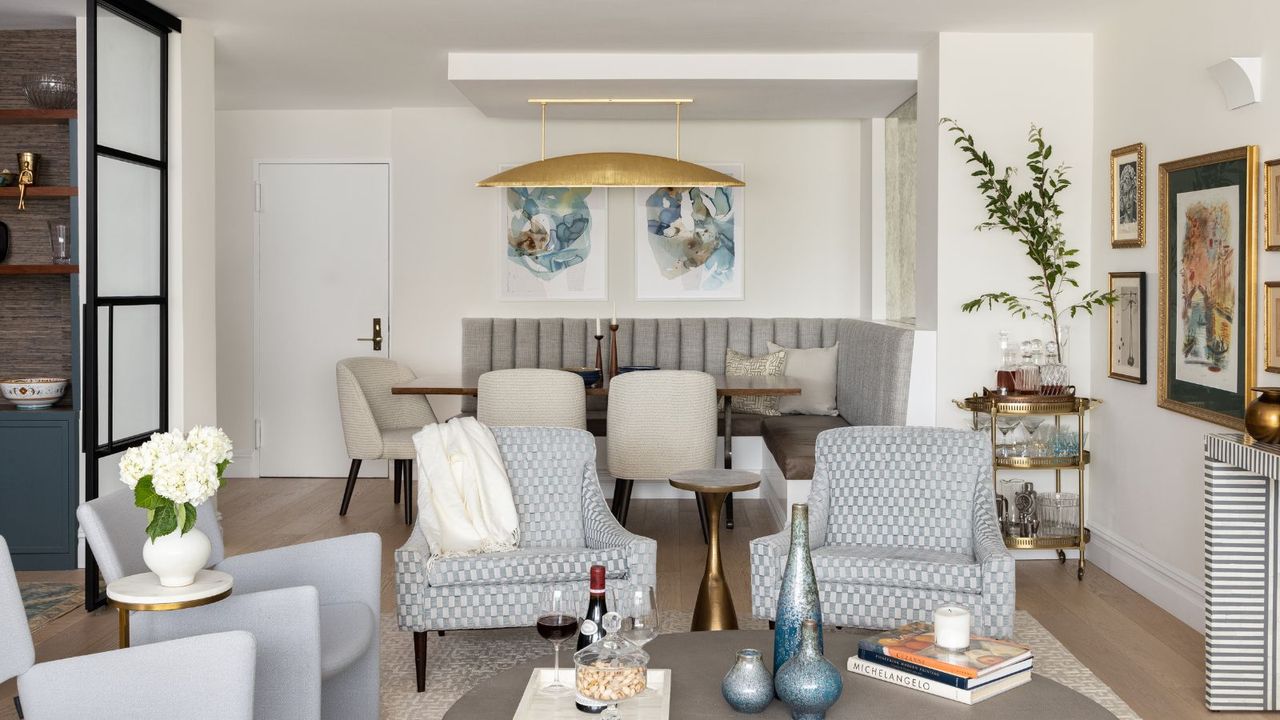 living room with white walls blue furniture and dining room behind