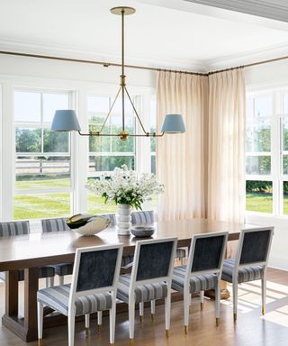 dining space in open plan kitchen with wooden rectangular table and dining chairs with striped upholstery