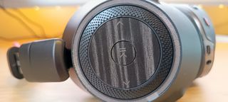 A pair of Poly Voyager 8200 UC headphones on a wooden desk