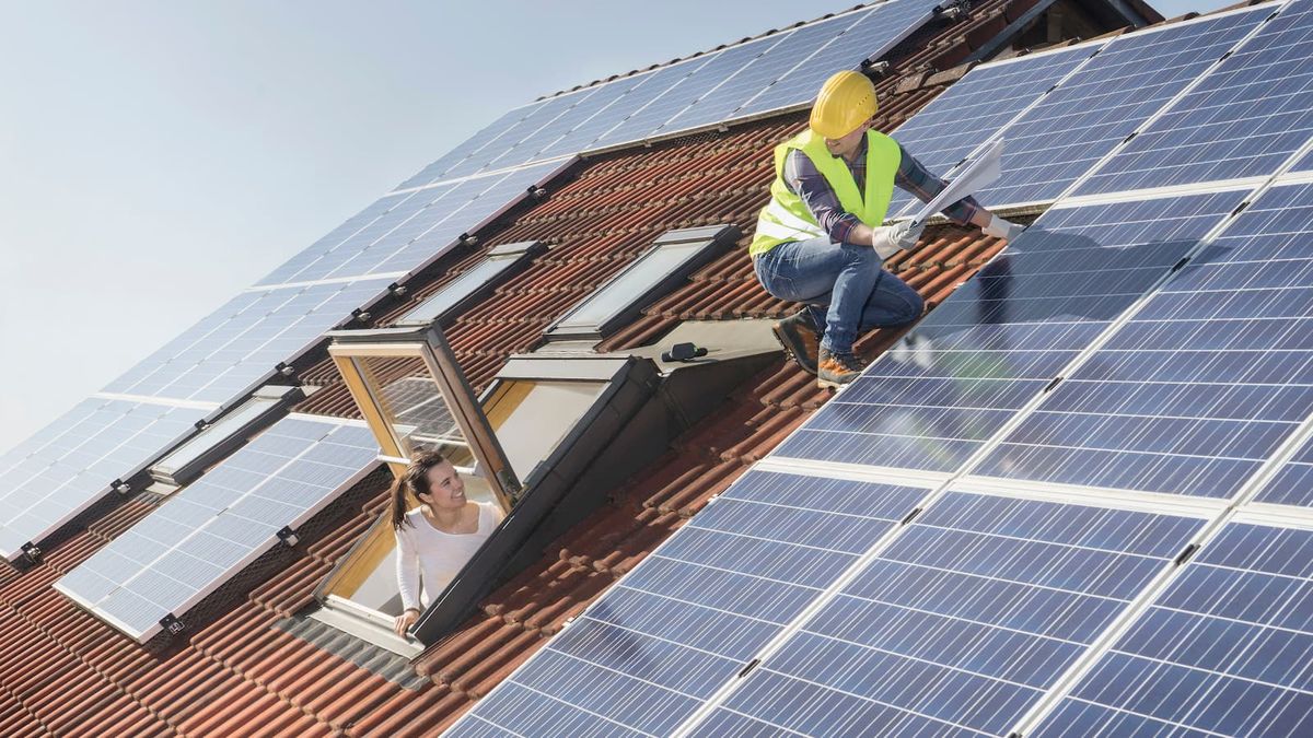 Solar panel engineer on a roof talking to a client