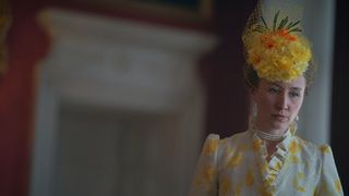 Erin Doherty in a yellow dress and fascinator as Princess Anne in The Crown S4
