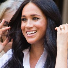 Meghan Markle pushes her hair away from her face