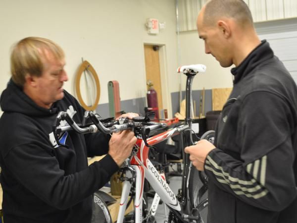 Team Type 1 head mechanic Andy Stone, left, sets up a Colnago Flight to be used by Laszlo Bodrogi, right, new to Team Type 1 for 2011.