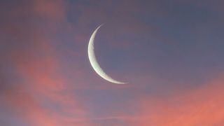 New Moon April 2023: Silhouette of mosque with crescent on sunset sky (cropped).