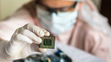 scientist holding microchip and checking electronic circuit