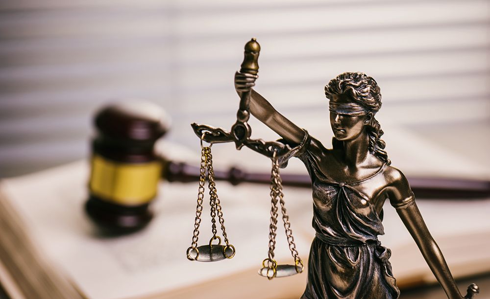 Lady Justice Against Gavel On Book