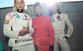 Models wear white logo top, pink jacket and bottom, and white jumpsuit
