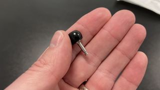 Flare Audio Isolate Pro earplug between a man's thumb and forefinger