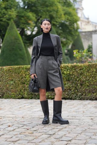 woman wearing blazer, turtleneck, bermuda shorts, and boots