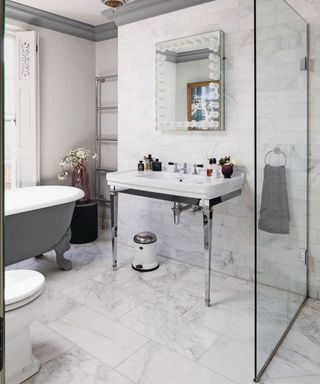 Modern white and grey bathroom with a free-standing bath, basin, toilet and walk in shower in a Georgian townhouse.