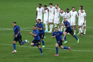 England players look dejected as Italy's footballers celebrate their win on penalties in the final of Euro 2020.