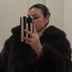 marina takes mirror selfie while wearing faux fur jacket