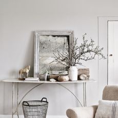 White console table with foxed glass mirror, and white and wooden objects