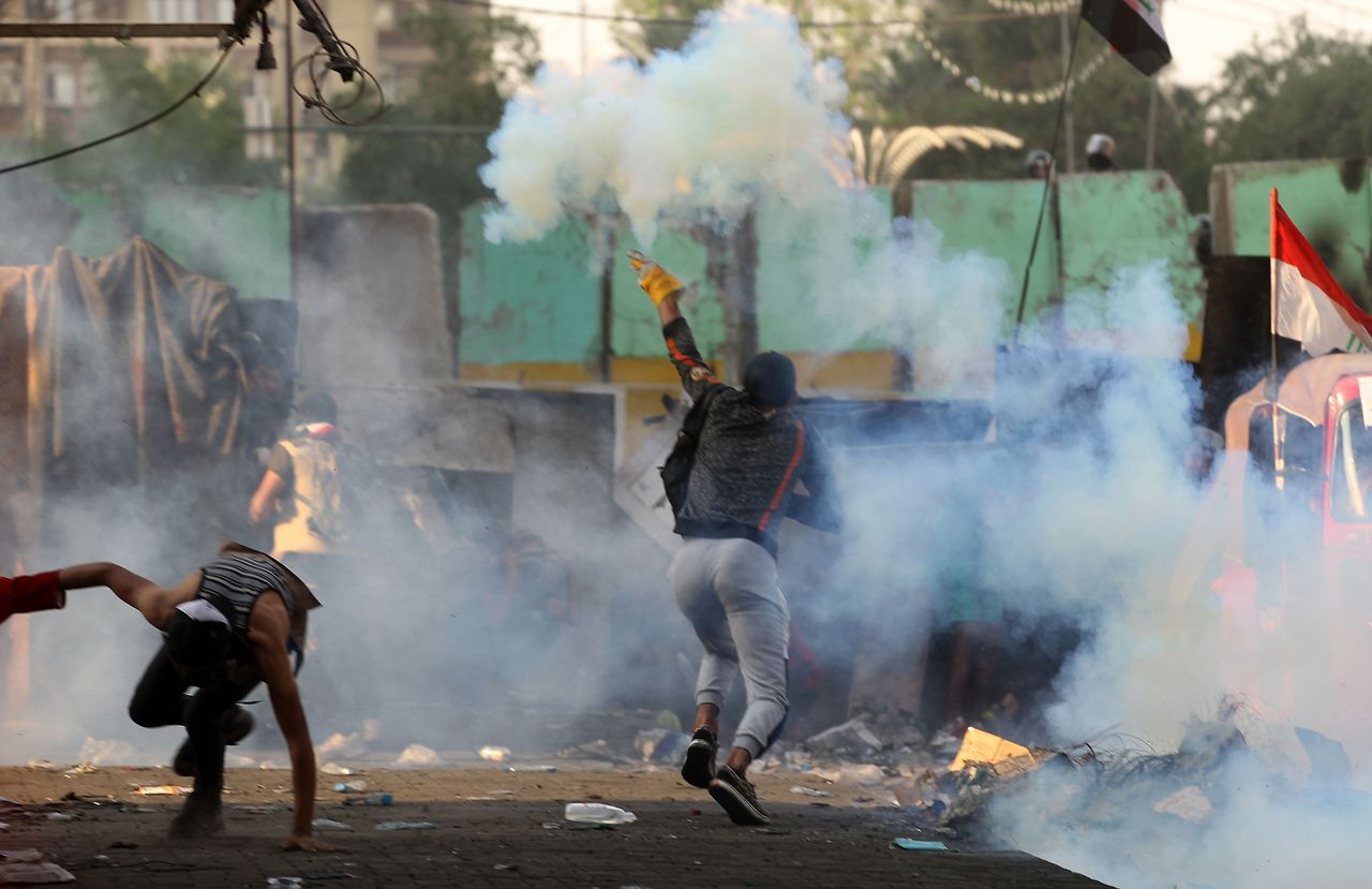 Iraqi protesters gather behind a road block during clashes with security forces at Baghdad&amp;#039;s Khallani square during ongoing anti-government demonstrations on November 13, 2019. (Photo by AHMA