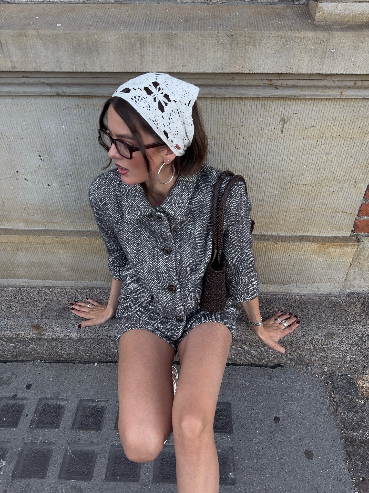 An image of @maryljean wearing a white crochet scarf, cropped grey blazer and matching skirt.