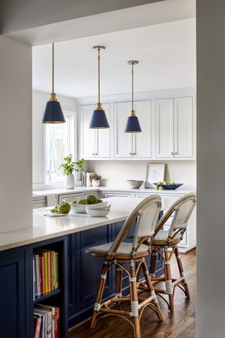 A kitchen with pendant lights above the island