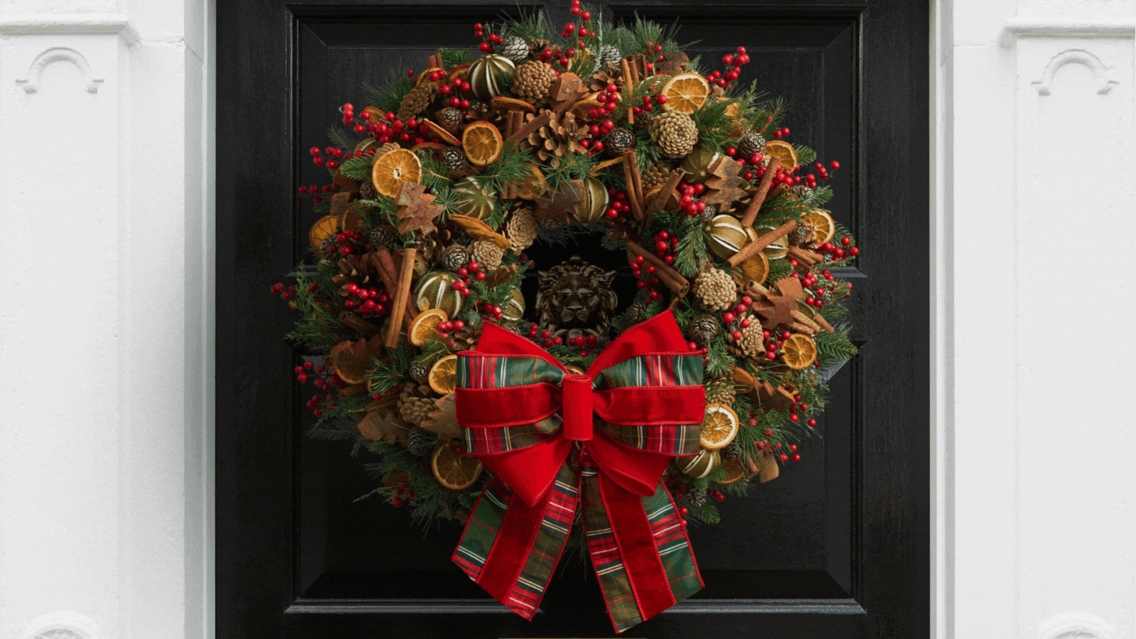 Rotating GIF of four different luxury Christmas wreaths hanging on a black door
