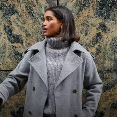 A woman wearing a grey coat and grey jumper from Dorothy Perkins.