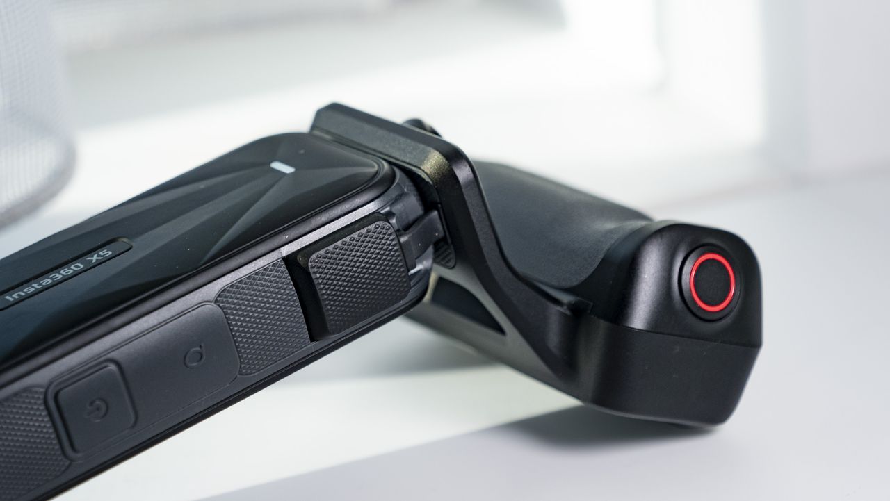 Insta360 X5 Photography Grip attached to the camera, on a plain white surface