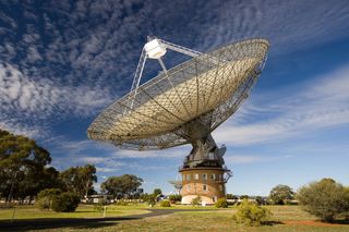The Parkes radio telescope in Australia is helping scientists monitor the regular light pulses from neutron stars, which could reveal the presence of a passing gravitational wave.