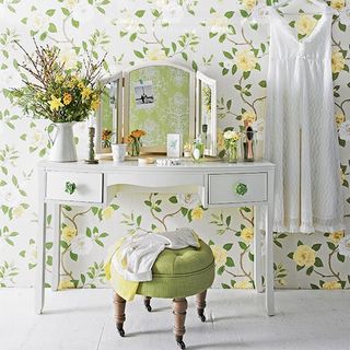 dressing area with mirror and floral wallpaper