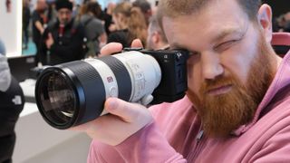 Sony FE 24-240mm lens attached to a Sony camera held up to a man's face