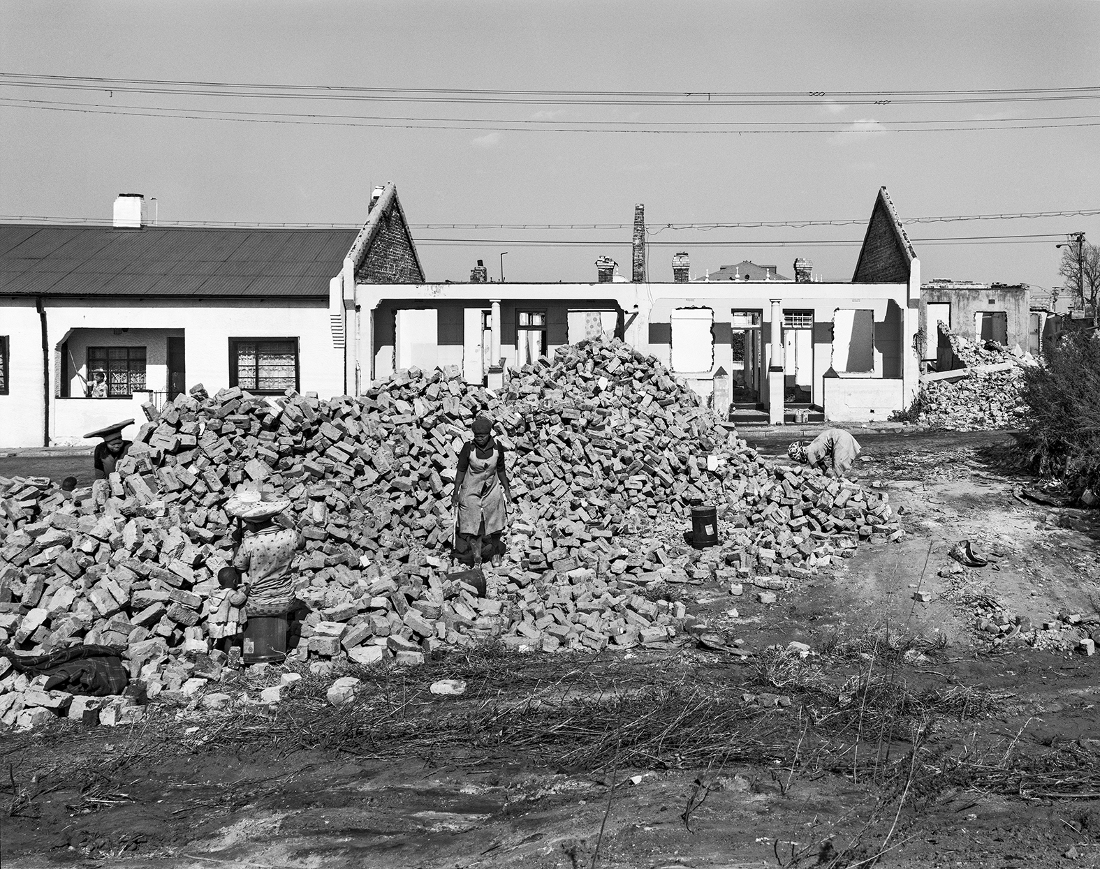 Zulu woman salvaging bricks for a white contractor from Indians' houses demolished under the Group Areas Act, Fietas