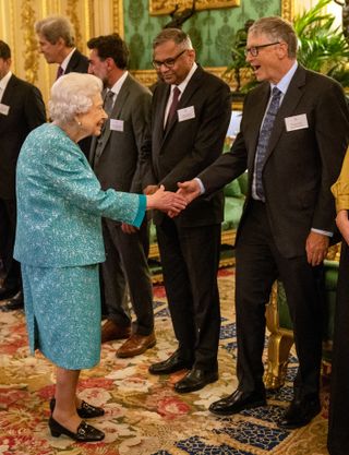 WINDSOR, UNITED KINGDOM - OCTOBER 19: Britain's Queen Elizabeth II (L) greets Microsoft co-founder turned philanthropist Bill Gates (R) during a reception for international business and investment leaders at Windsor Castle to mark the Global Investment Summit on October 19, 2021 in Windsor, England. (Photo by Arthur Edwards-Pool/Getty Images)