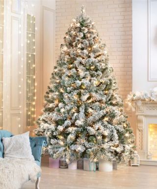 A Christmas tree in a living room with a wall of hanging string lights and furry pillows