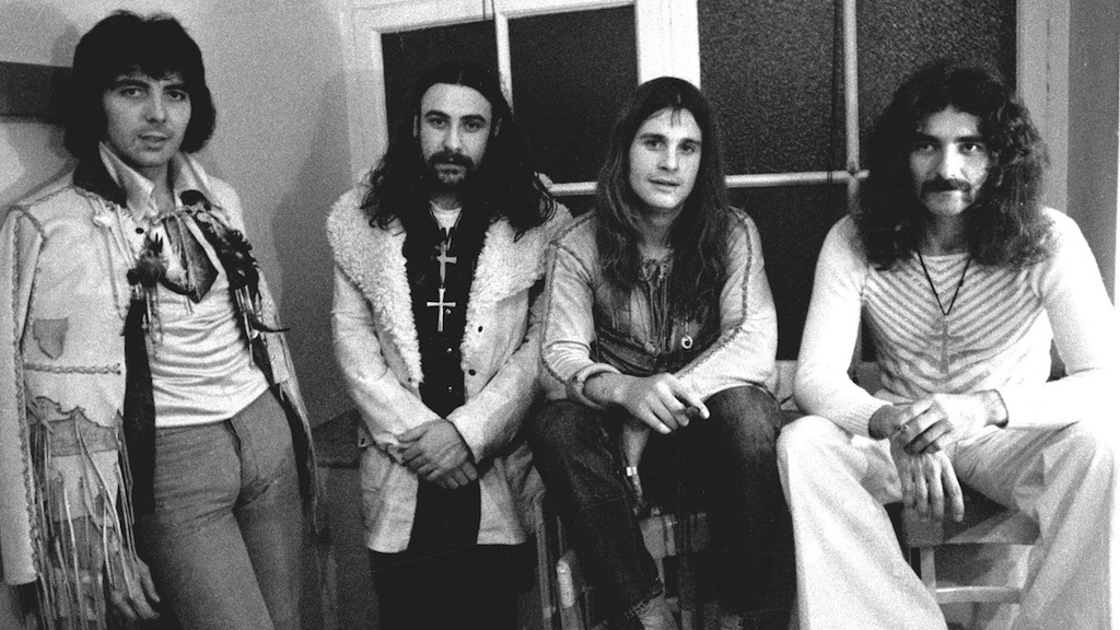 Black Sabbath standing in front of a window.