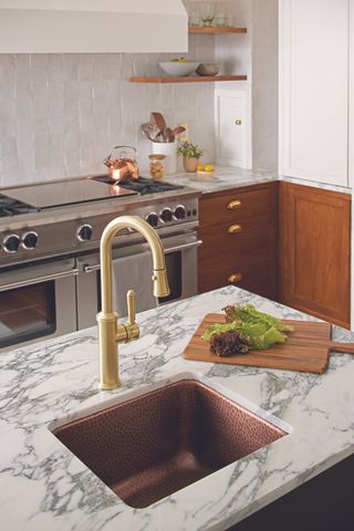 A kitchen bar with copper sink and gold faucet