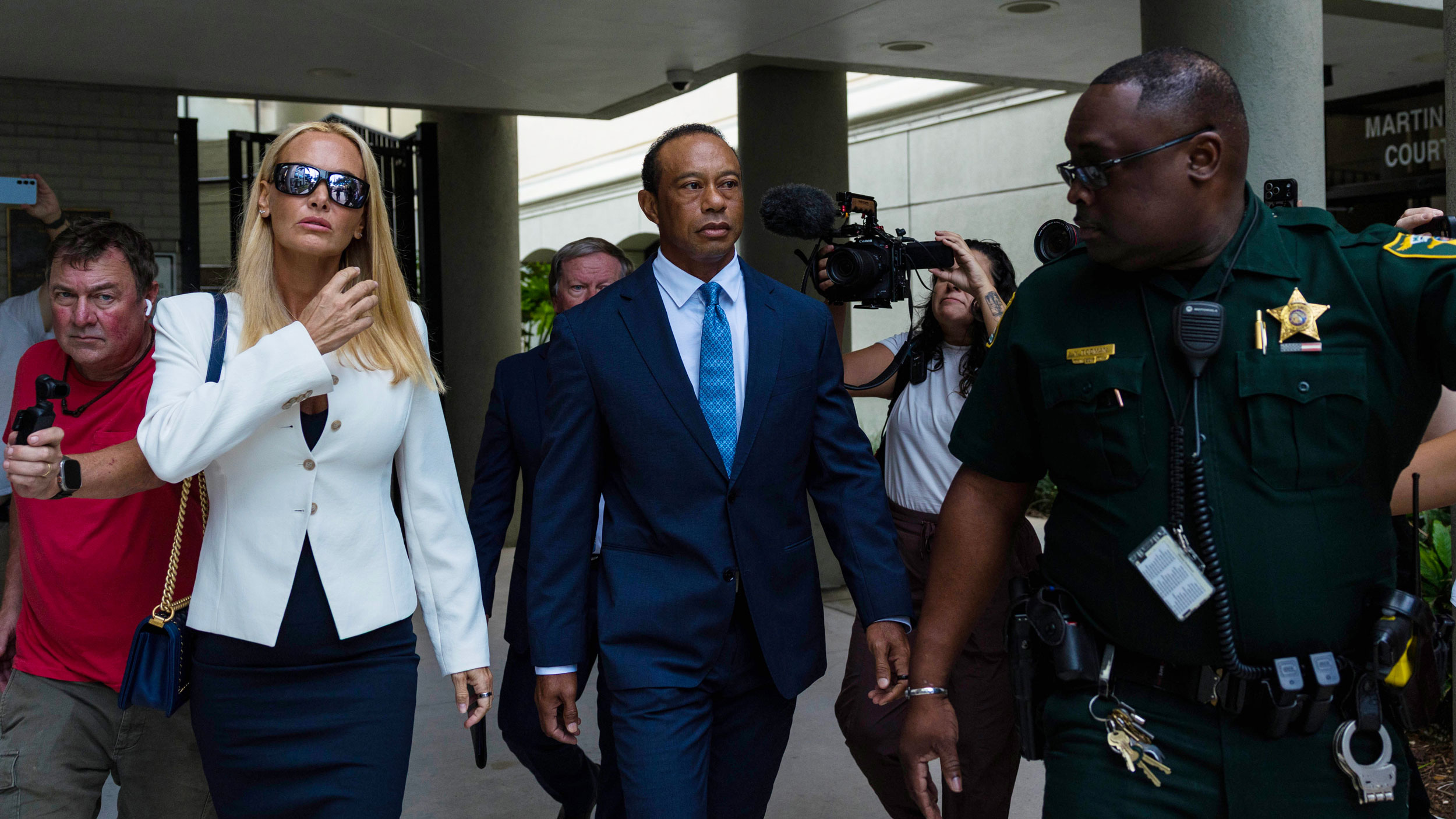 Tiger Woods (centre) and Vanessa Trump walk towards a south Florida courtroom on Wednesday, September 2