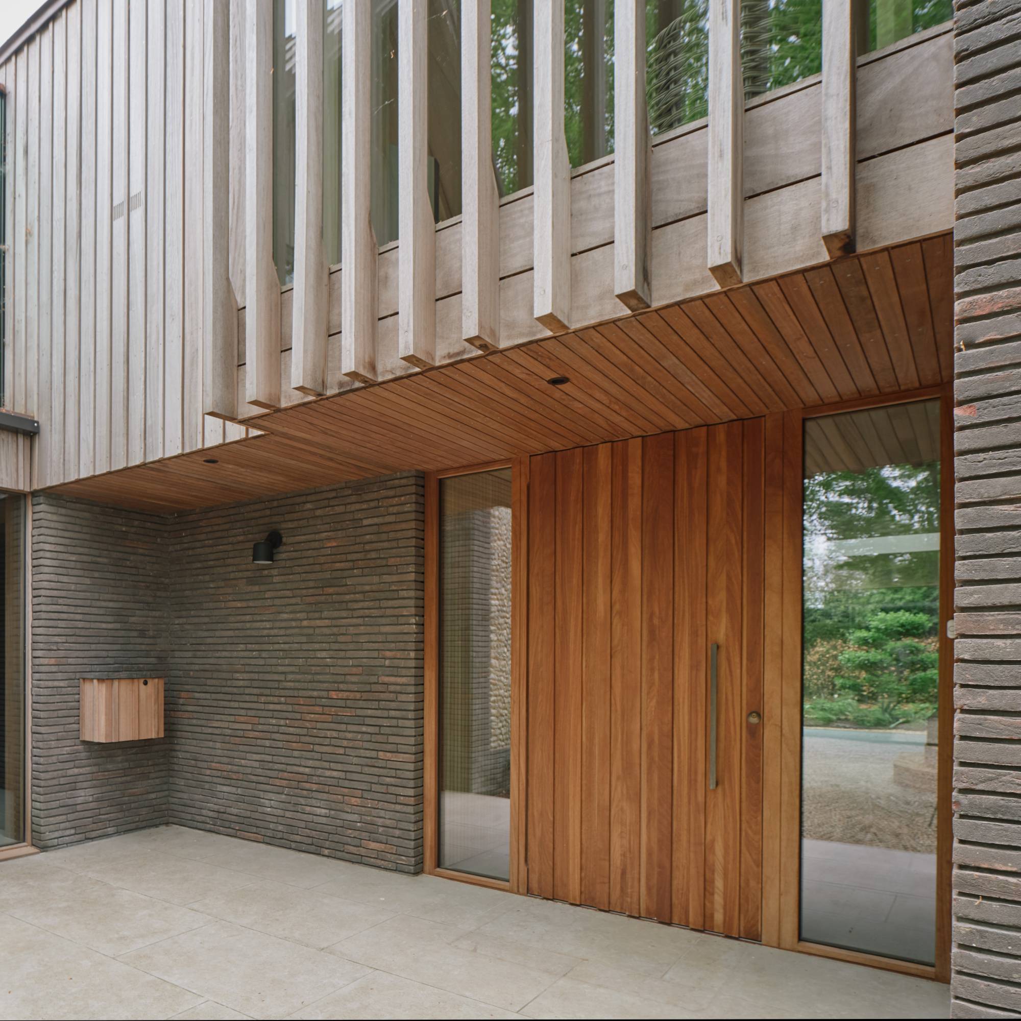 Iroko timber front door with windows on modern house