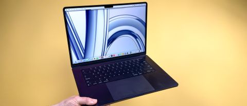 MacBook Air 15-inch M3 in hand with yellow background