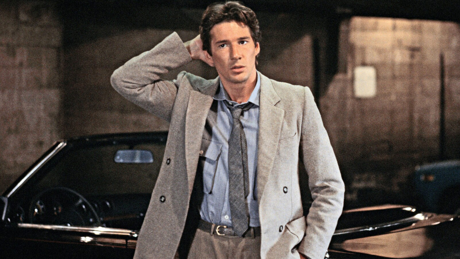 Richard Gere holding is head, in a decent suit.
