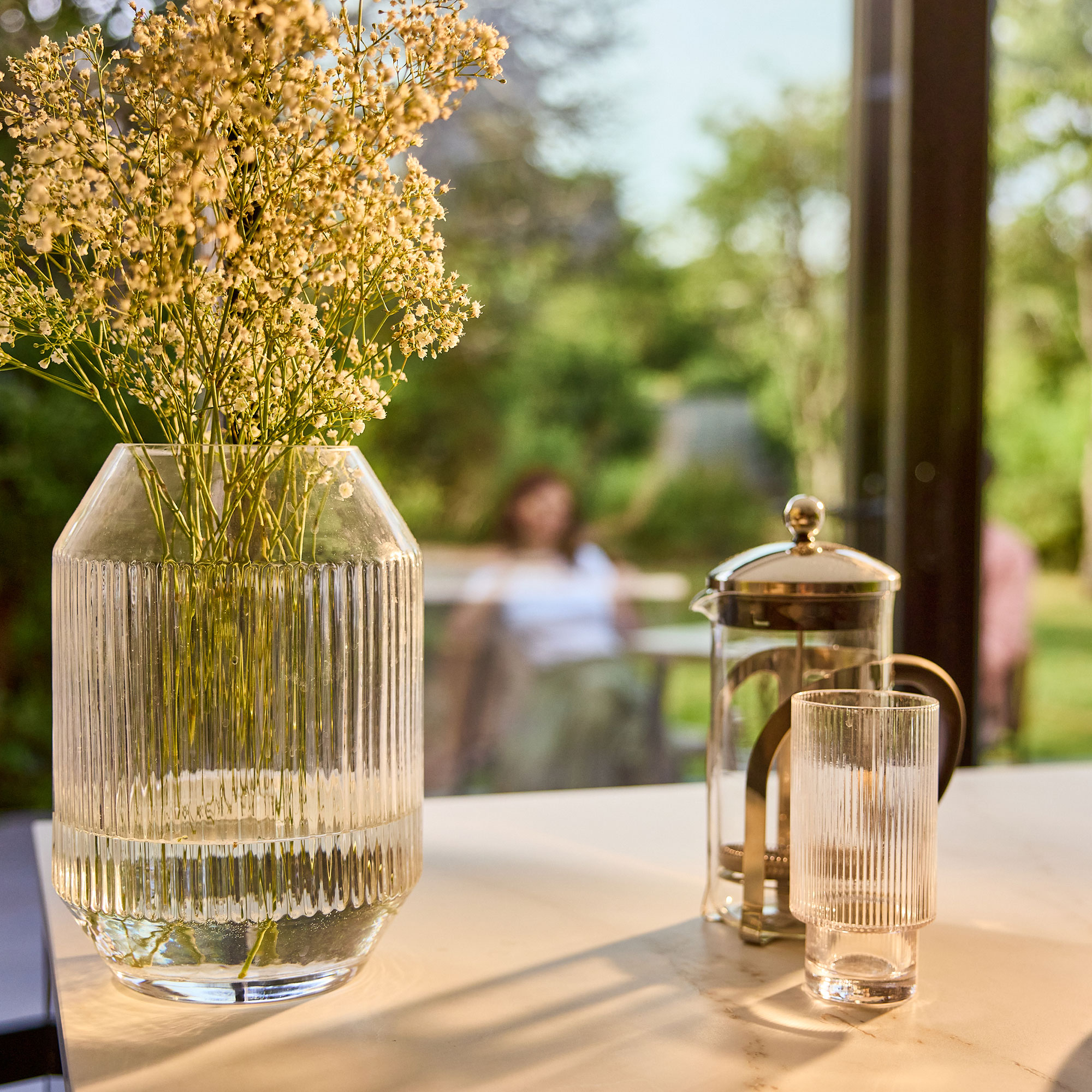 Vase of flowers and cafetiere on countertop