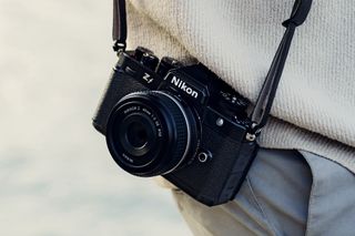 Nikon Z f en una correa al lado del fotógrafo