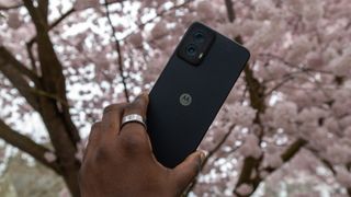 The Moto G Power 5G 2024 in hand with cherry blossoms behind